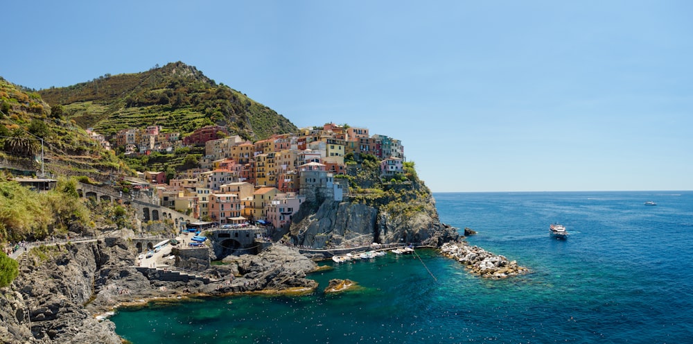 houses on mountain beside sea during daytime