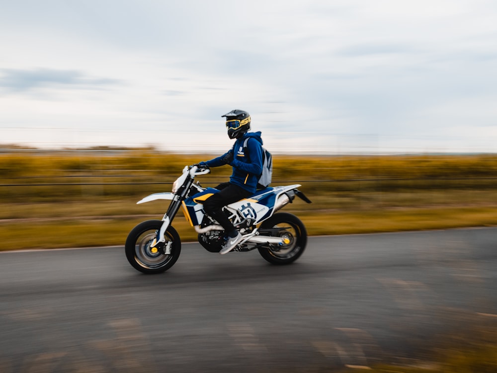 白と黒のバイクに乗る黒いジャケットの男