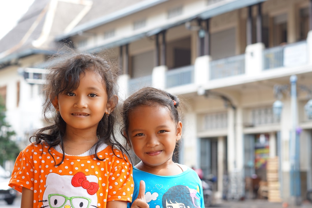2 girls in blue and white crew neck shirt smiling,