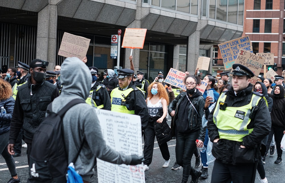 Personnes debout près d’un bâtiment brun pendant la journée