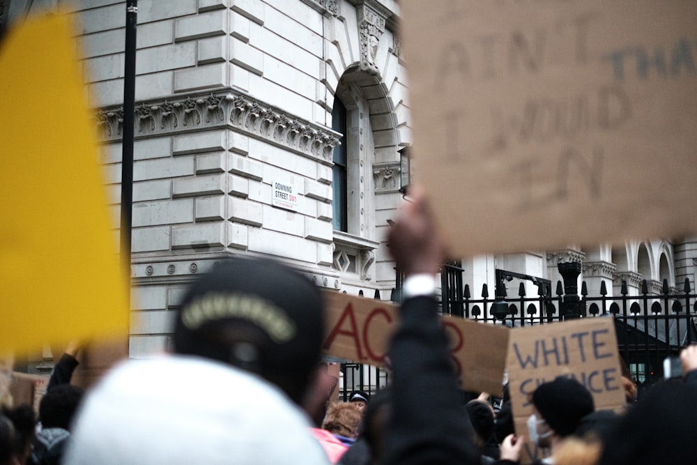 people in black and yellow uniform standing near building during daytime