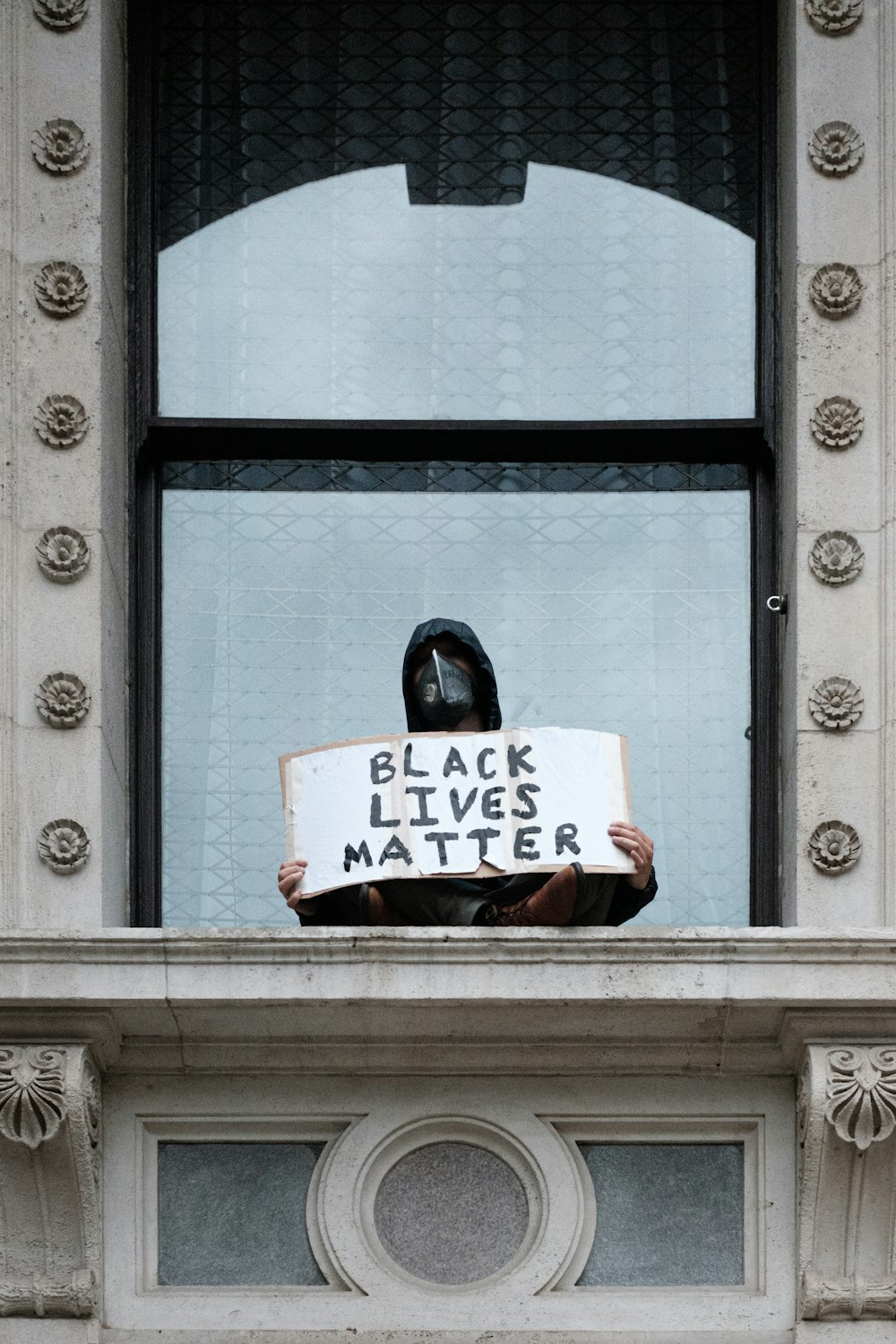 Una persona sosteniendo un cartel que dice Black Lives Matter
