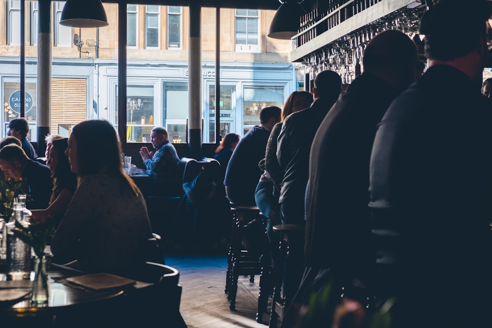 people sitting on chairs near glass window during daytime