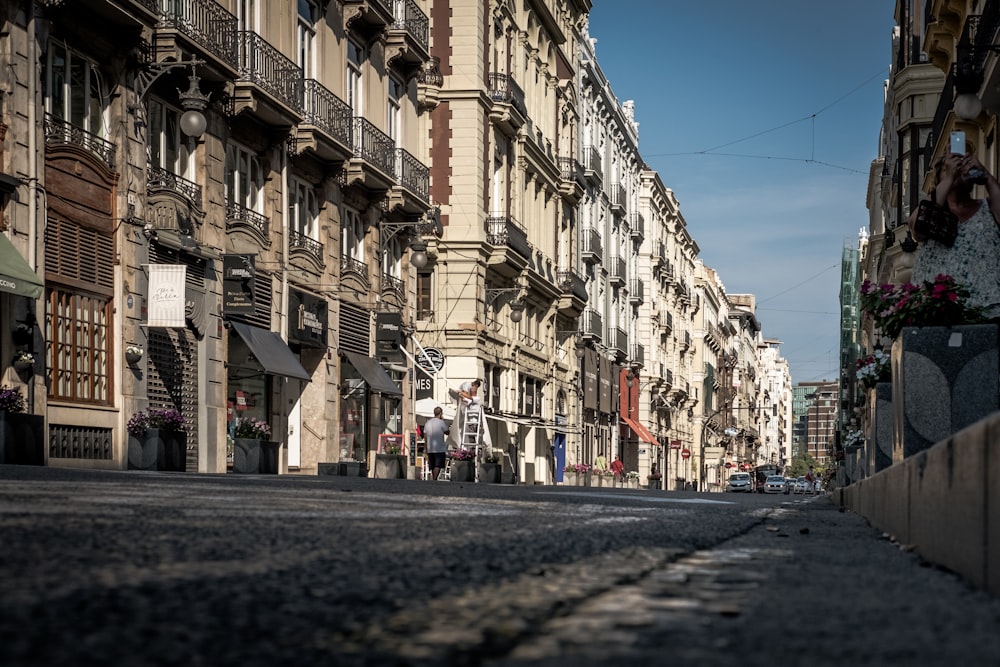 personas que caminan por la calle entre edificios durante el día