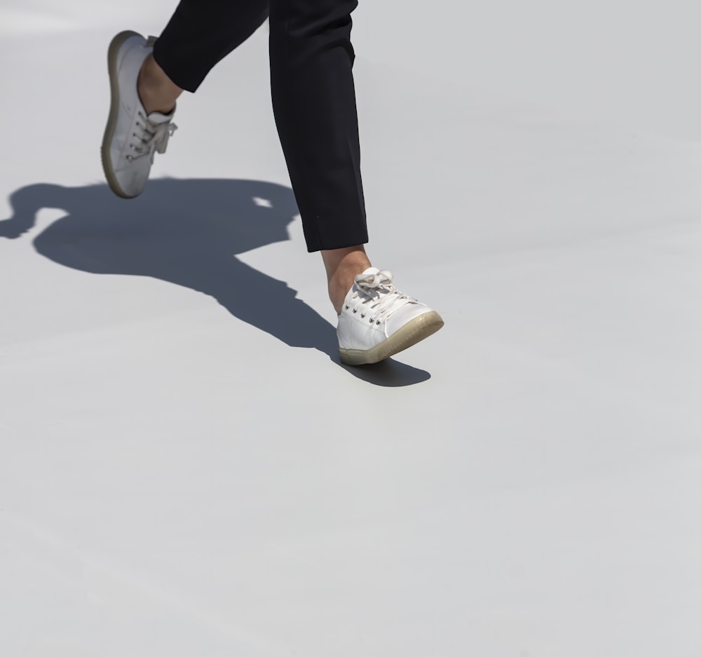 person in black pants and white sneakers