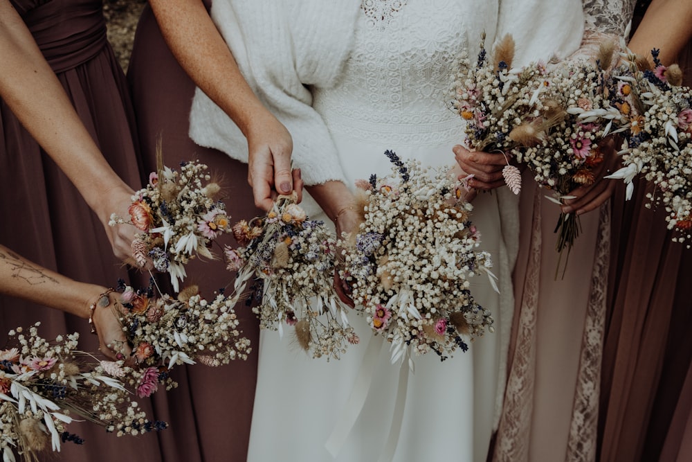 woman in white dress holding bouquet of flowers