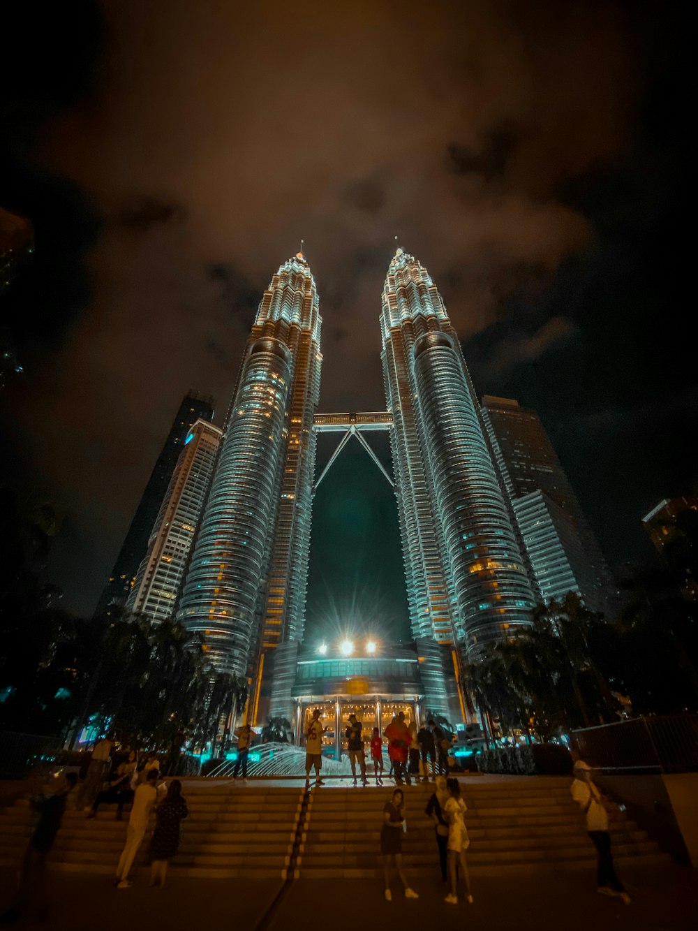 people walking on street near lighted buildings during night time