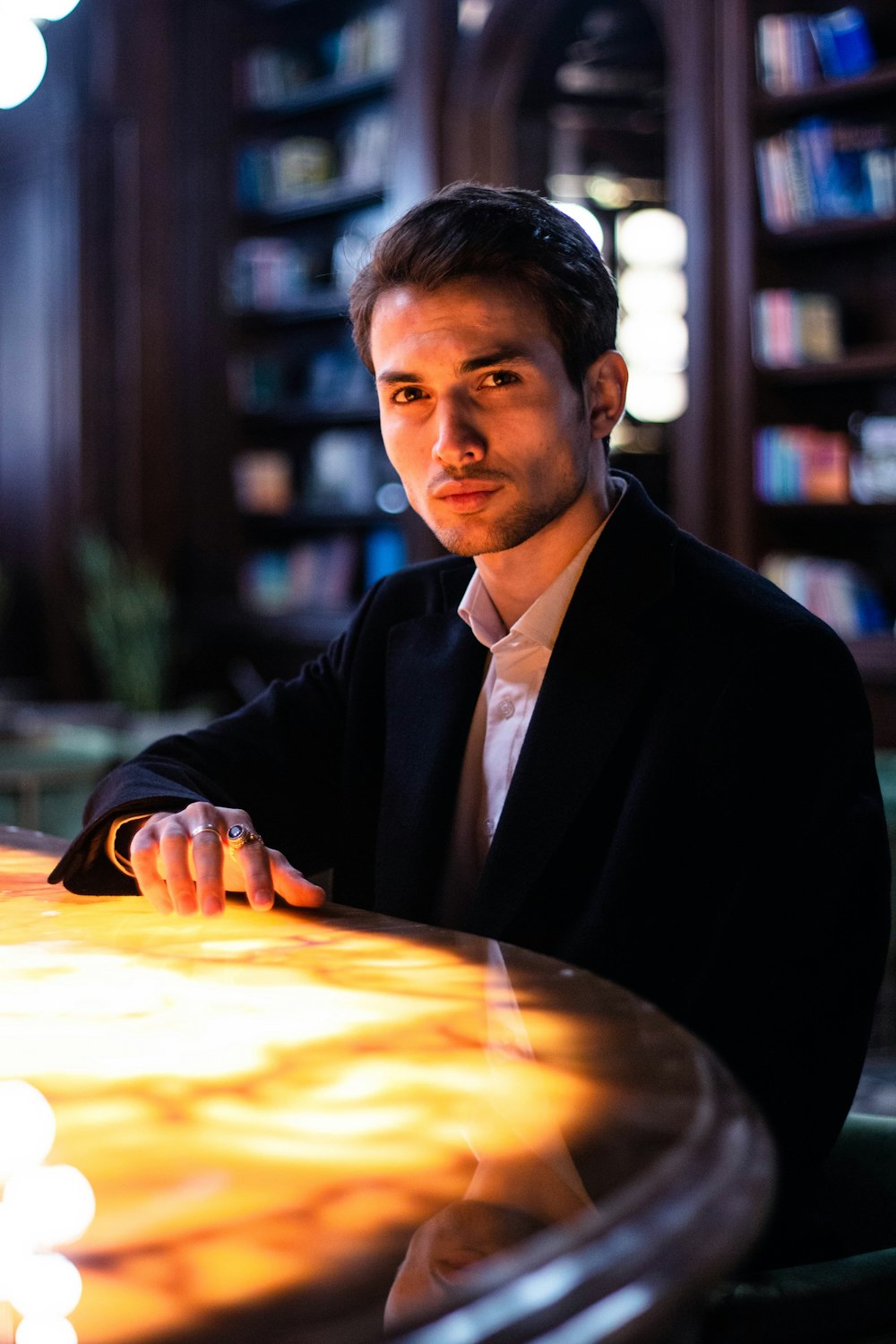 man in black suit jacket sitting at the table