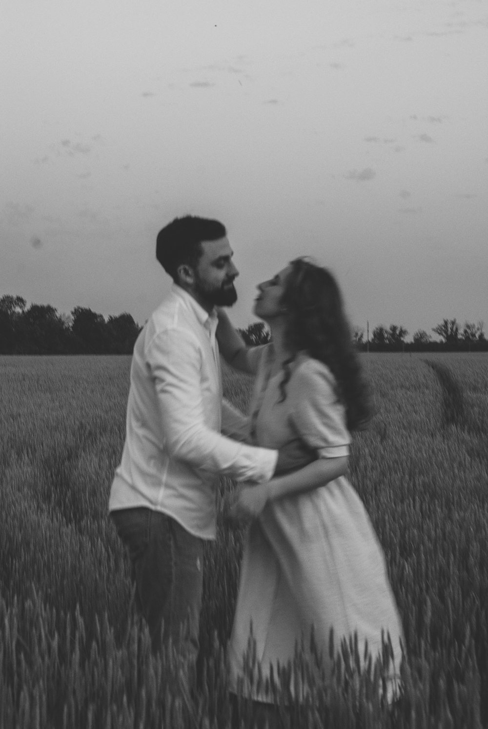 homem e mulher que se beijam no campo de grama durante o dia