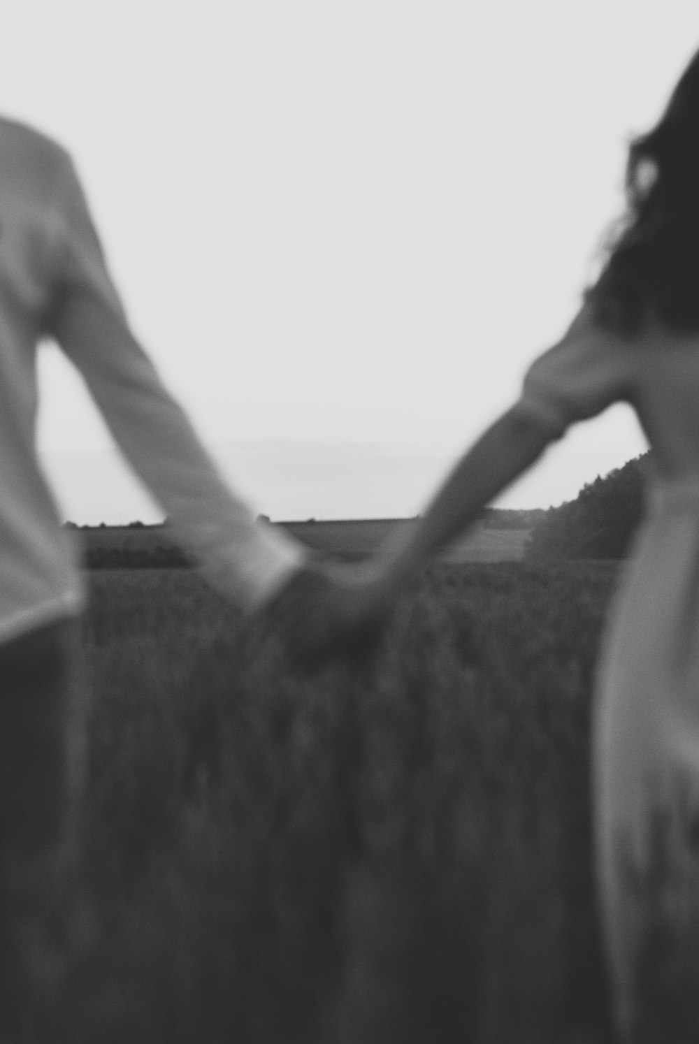 grayscale photo of man and woman holding hands