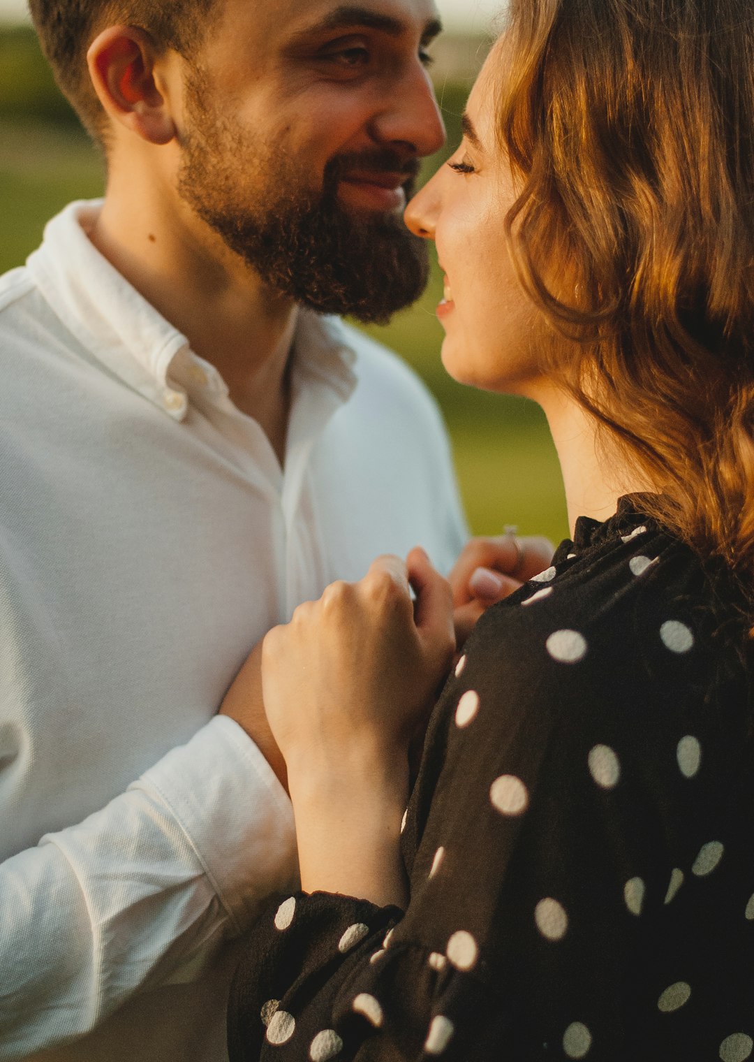 man in white dress shirt kissing woman in black and white polka dot dress