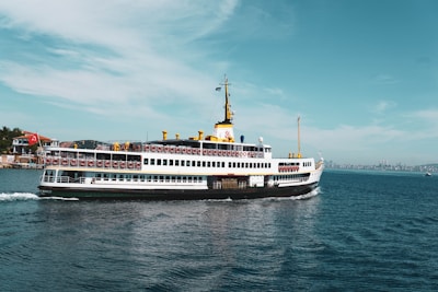 white and blue ship on sea under blue sky during daytime