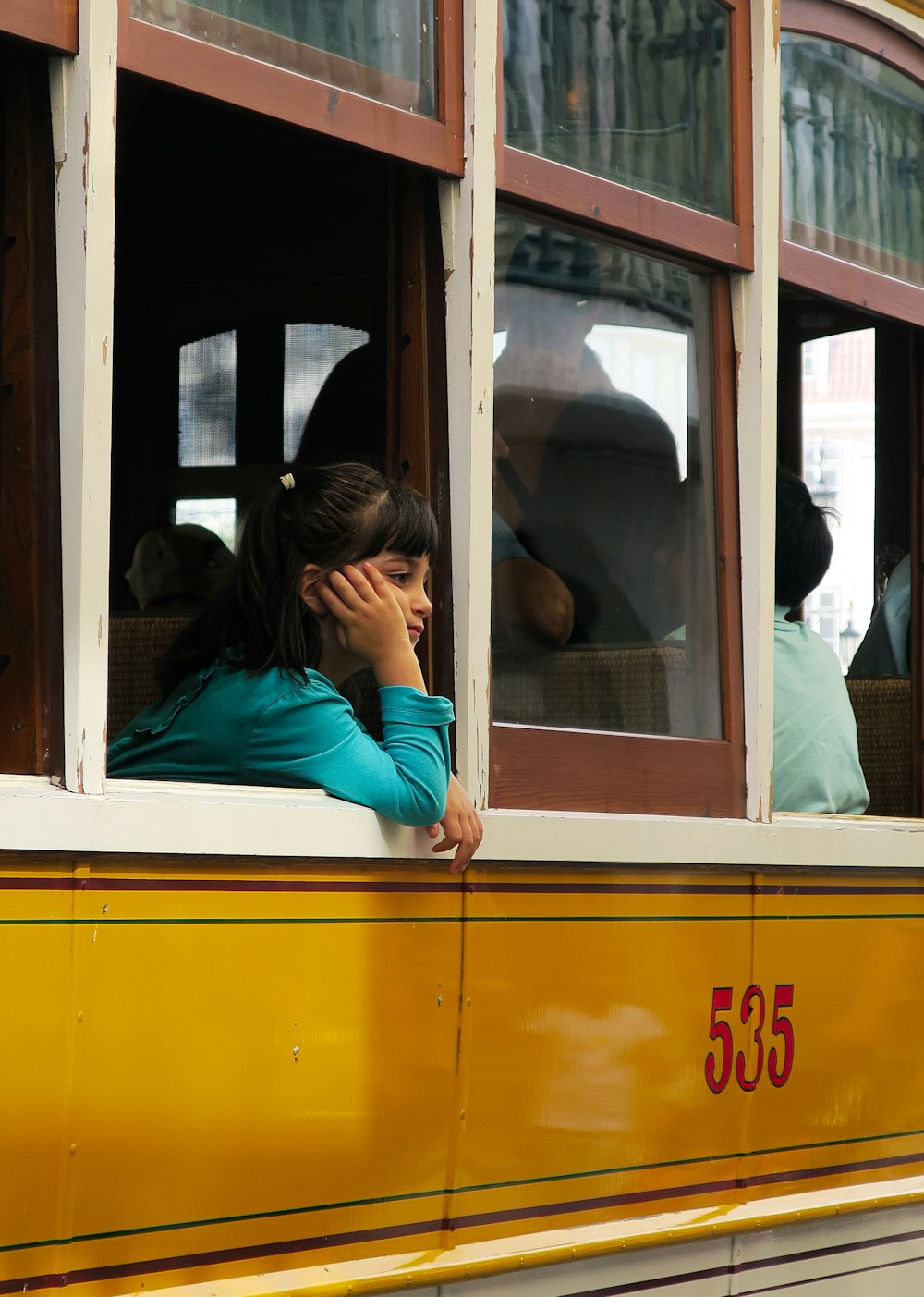 woman in teal long sleeve shirt sitting inside train