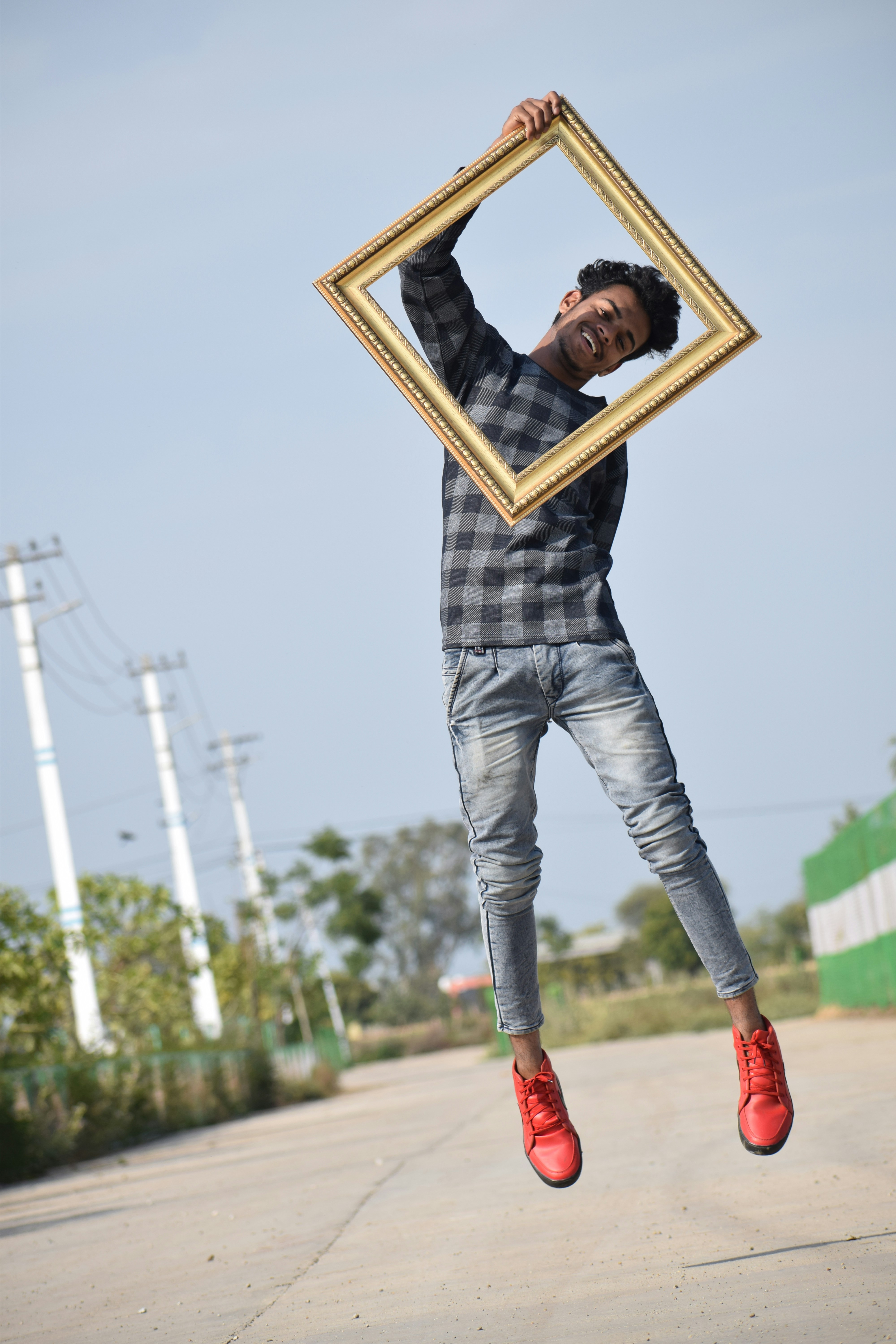 man in blue long sleeve shirt and blue denim jeans holding brown wooden picture frame