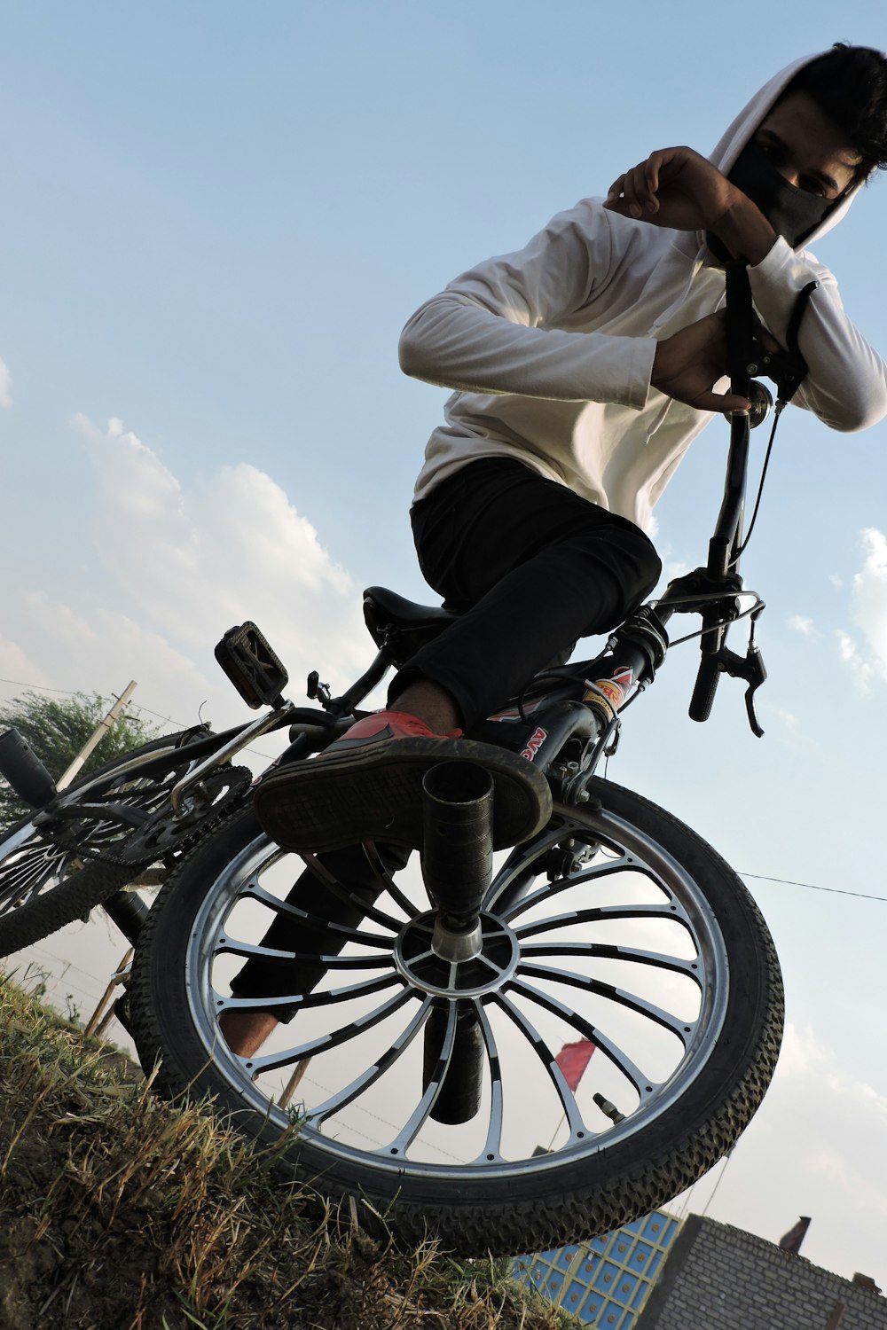 a man riding a bike on top of a grass covered hillside