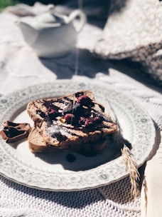 A cozy kitchen scene with a slice of toast generously spread with chocolate and sprinkled with seeds.
