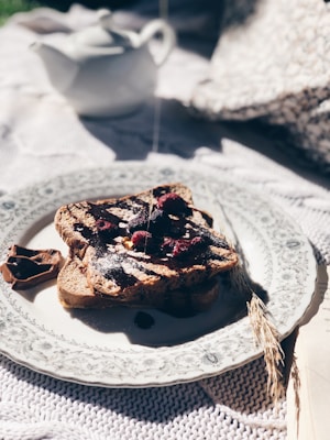A cozy kitchen scene with a slice of toast generously spread with chocolate and sprinkled with seeds.