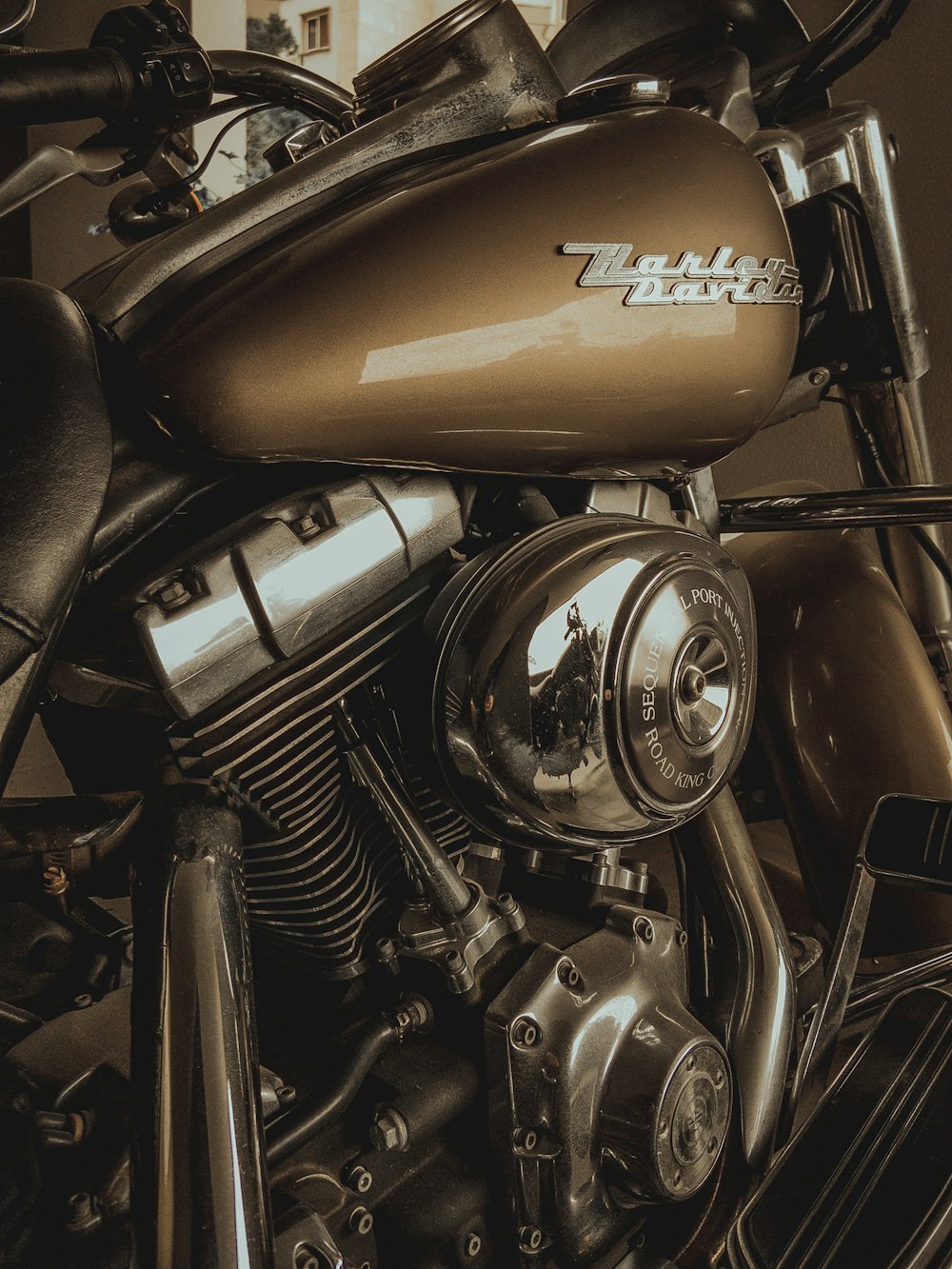 a close up of a motorcycle engine with a building in the background