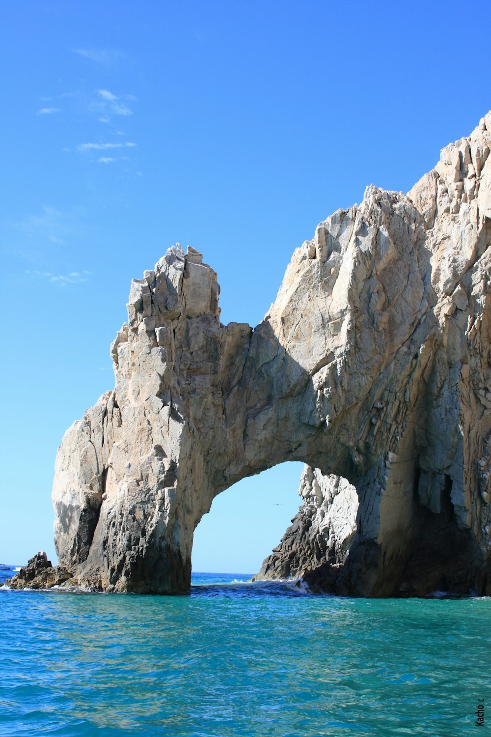 formación rocosa gris en el mar bajo el cielo azul durante el día