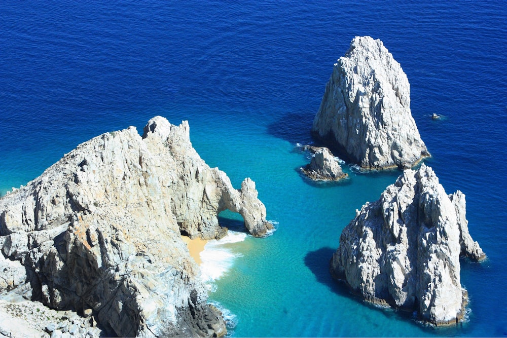 formação rochosa branca no mar azul durante o dia