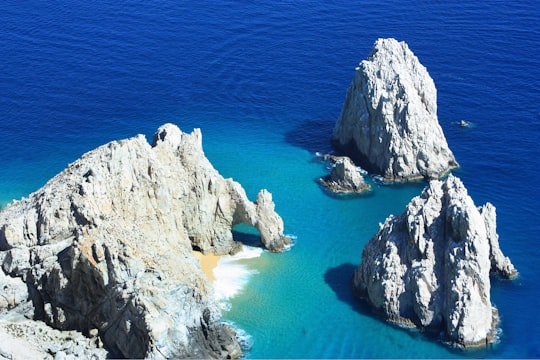 white rock formation on blue sea during daytime in Cabo Mexico