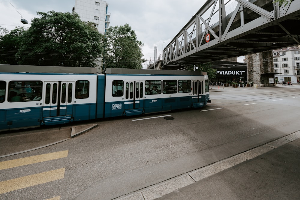 blue and white train on rail road during daytime