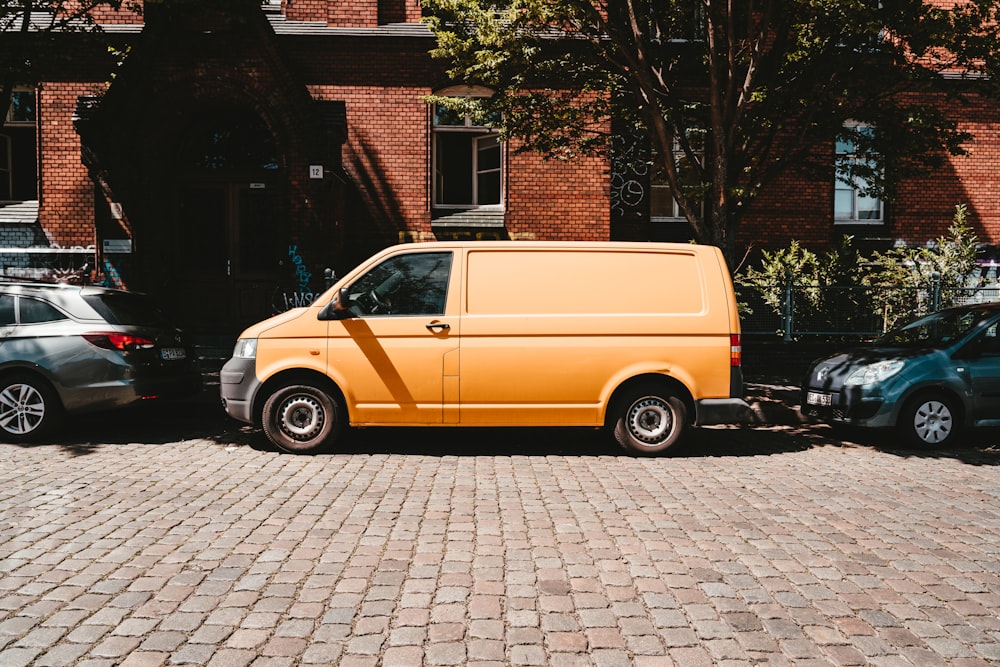 Furgoneta amarilla aparcada junto a un edificio de ladrillos marrones