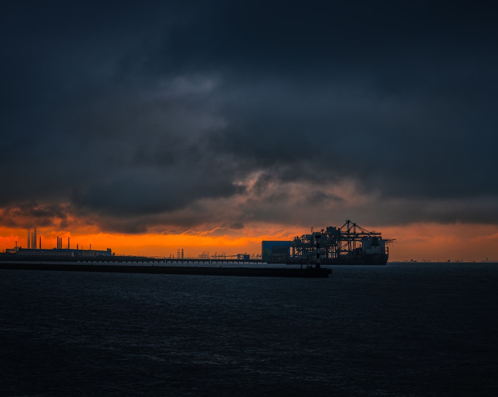 silhouette of ship on sea during sunset