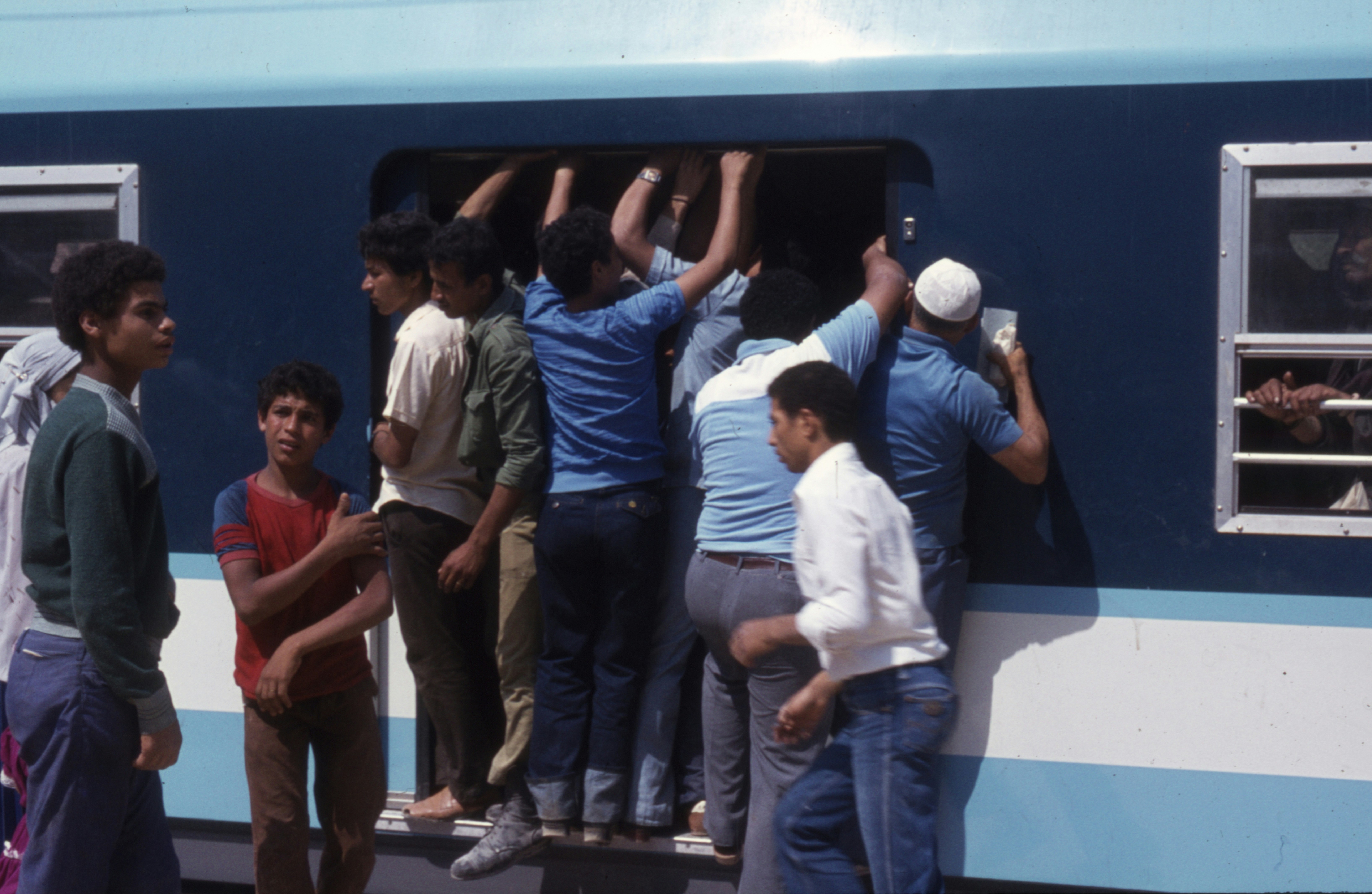 एक यात्री अपने मोबाइल पर PNR स्टेटस चेक करते हुए, ट्रेन की डिब्बे के अंदर