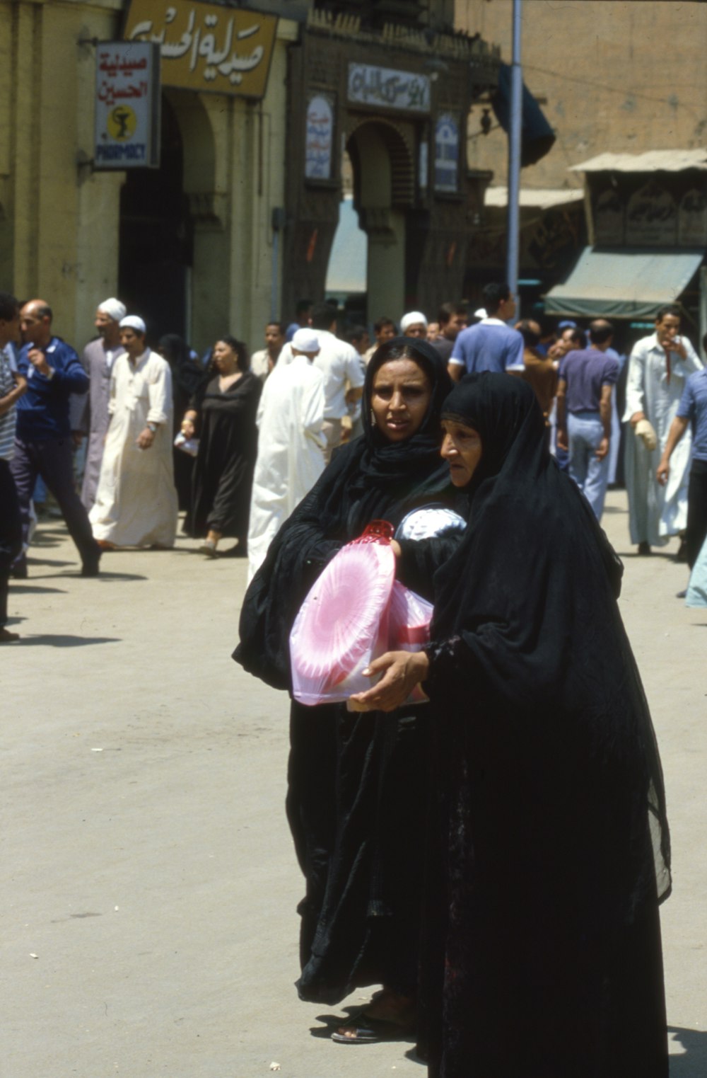 woman in black hijab and abaya standing on street during daytime