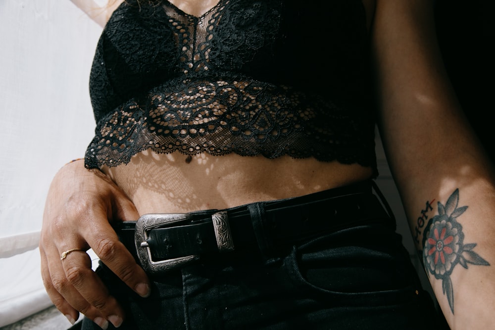 woman in black and gray lace brassiere and black denim jeans