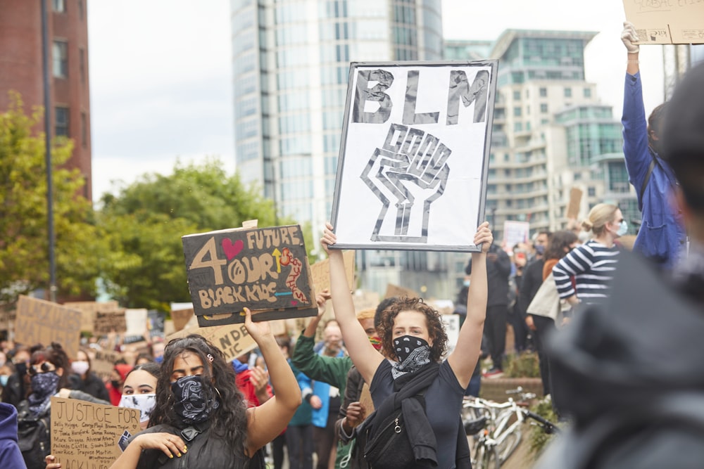 people holding a signage during daytime