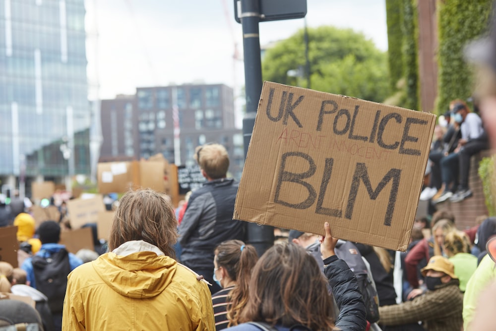 a man holding a sign that reads uk police bim