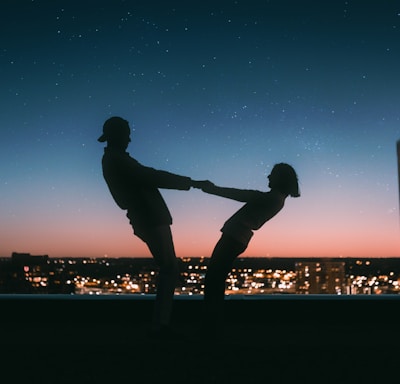 silhouette of man jumping on the field during night time