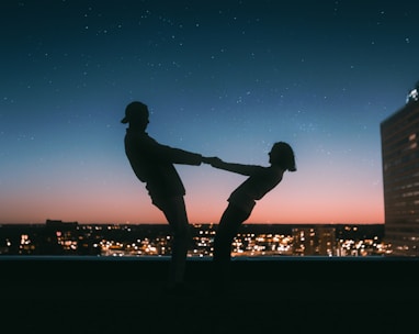 silhouette of man jumping on the field during night time