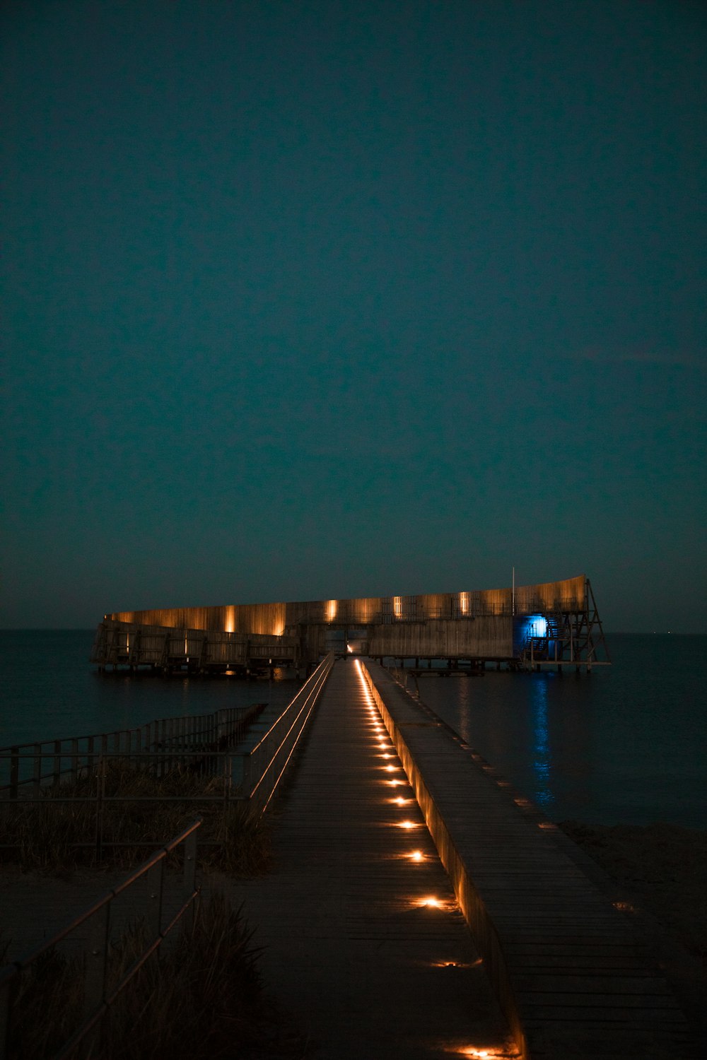 brown wooden dock on sea during night time
