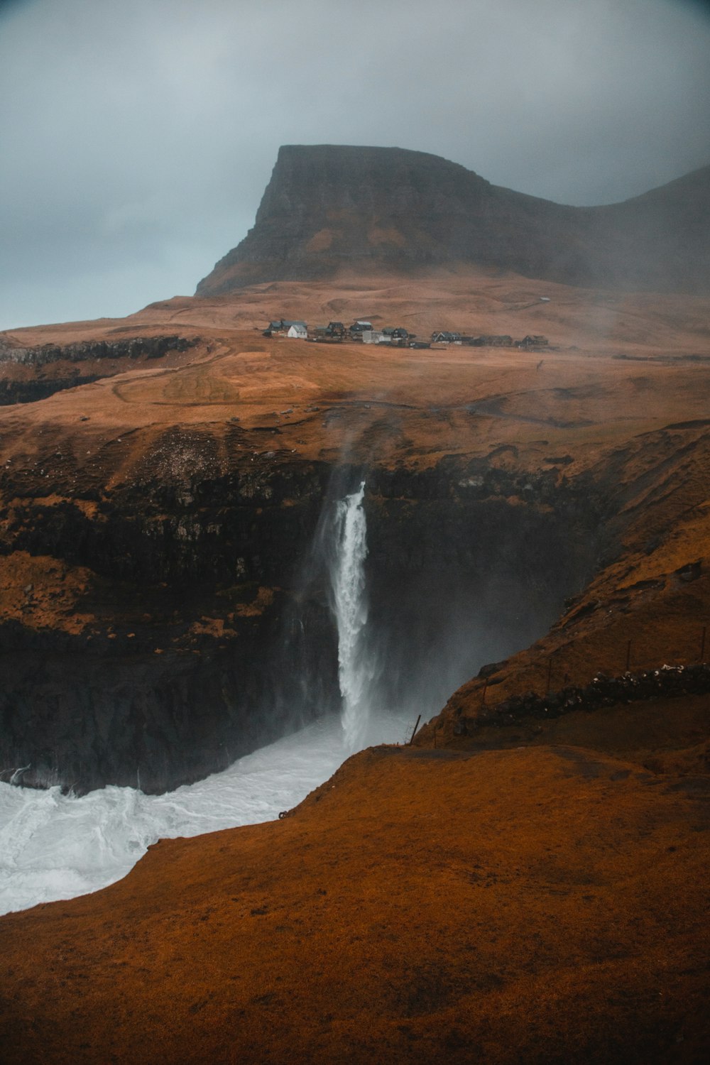 waterfalls on brown rocky mountain during daytime