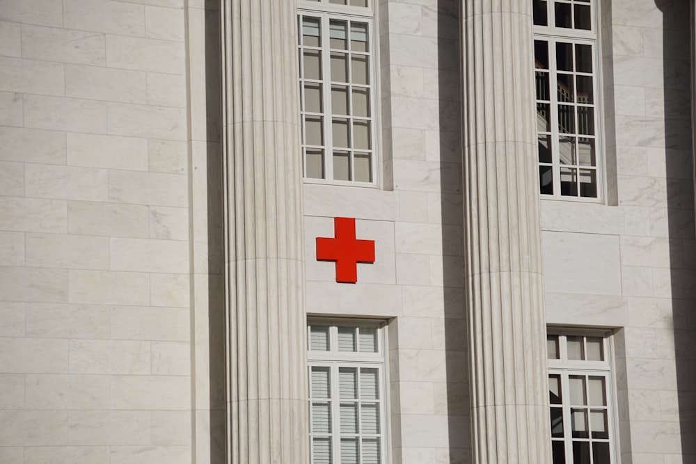 Cruz roja sobre edificio de hormigón blanco