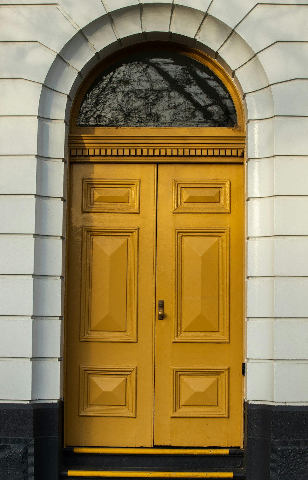 brown wooden door on white concrete wall