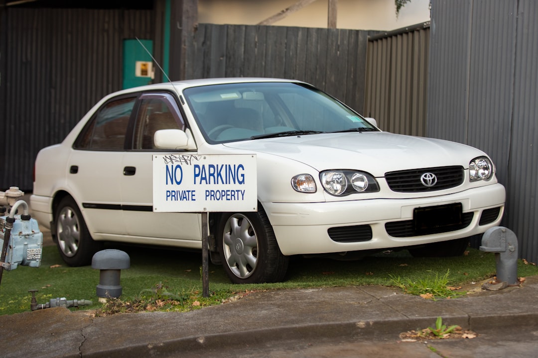 white mercedes benz sedan parked near brown wooden fence