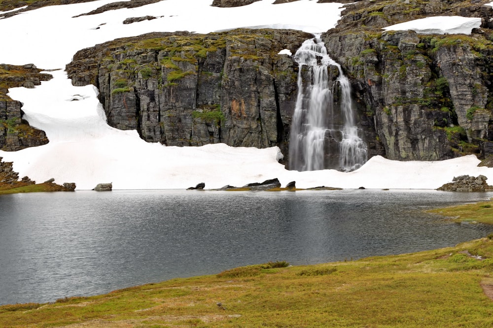 waterfalls on green grass field during daytime