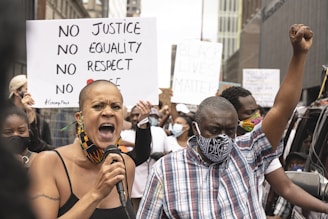 A passionate crowd holding bullhorns and signs demanding justice from fraudulent businesses.