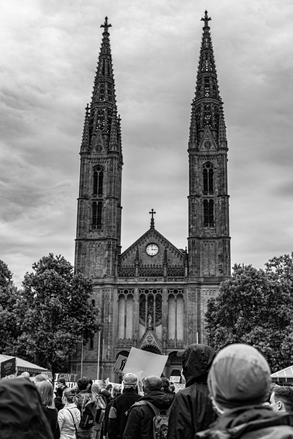 grayscale photo of church near trees