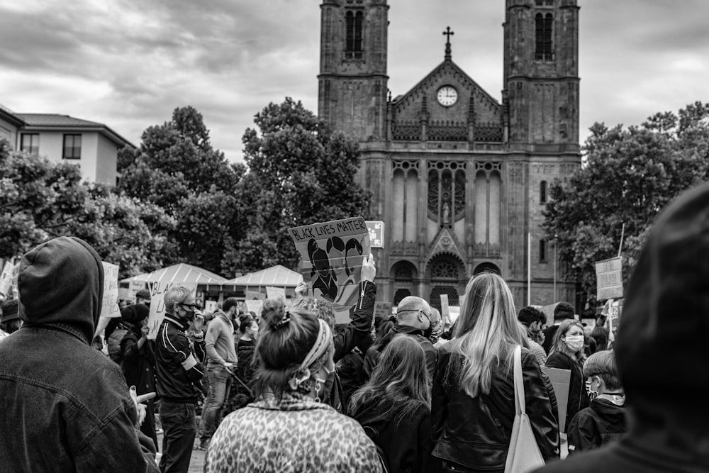 grayscale photo of people in front of cathedral