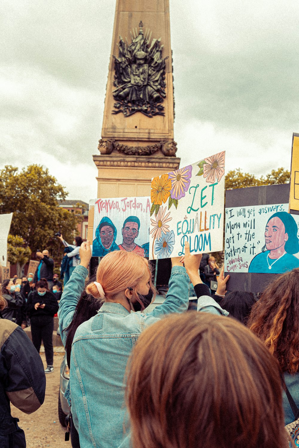 people holding blue and white signage during daytime