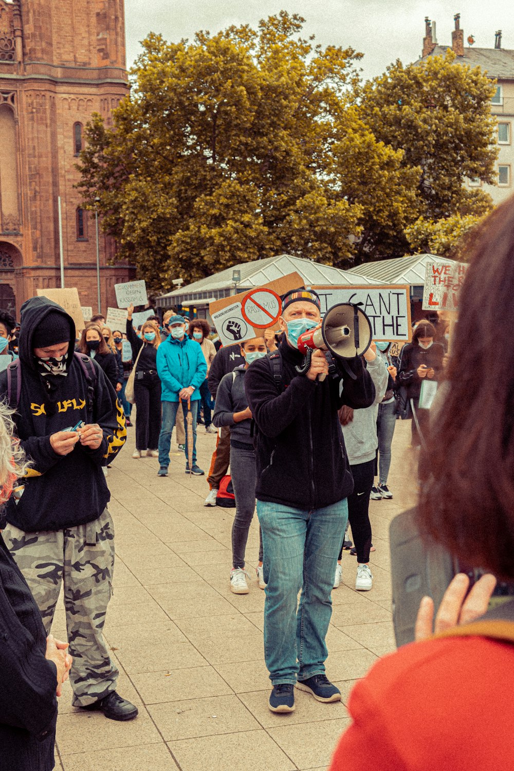 a group of people standing on a sidewalk holding signs