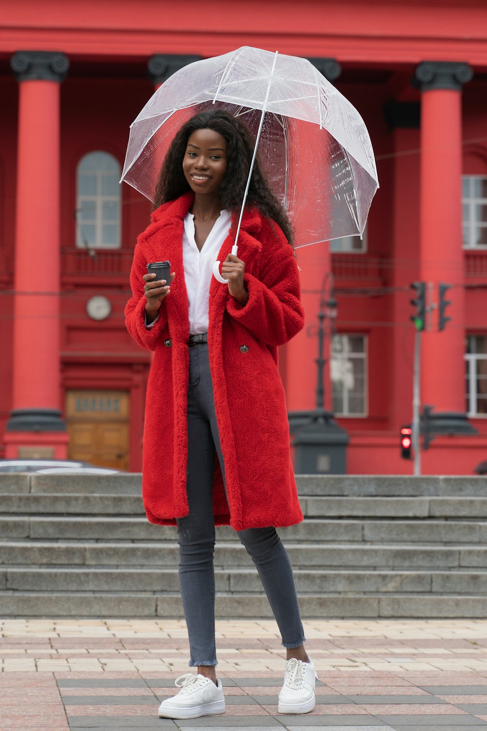 woman in red coat holding umbrella
