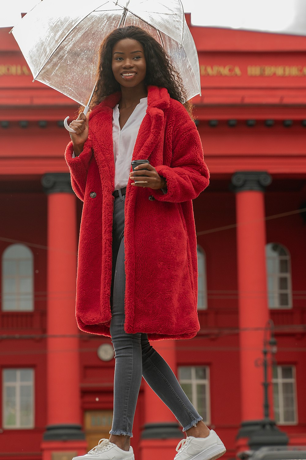 woman in red coat holding umbrella