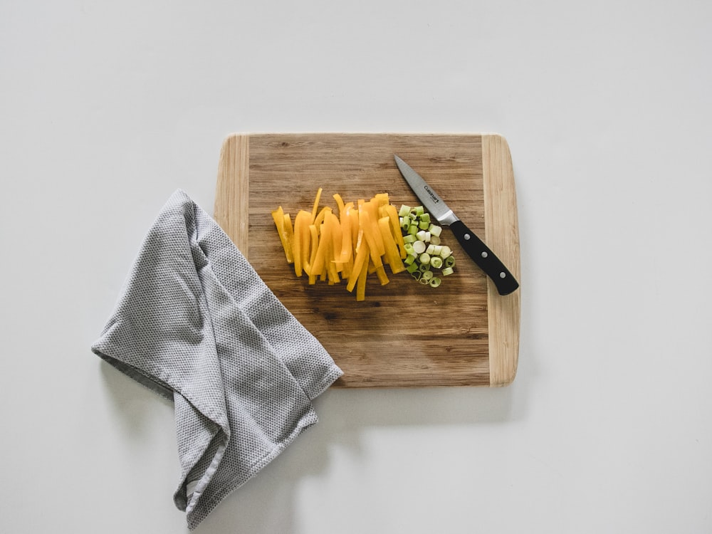 yellow pasta on brown wooden chopping board