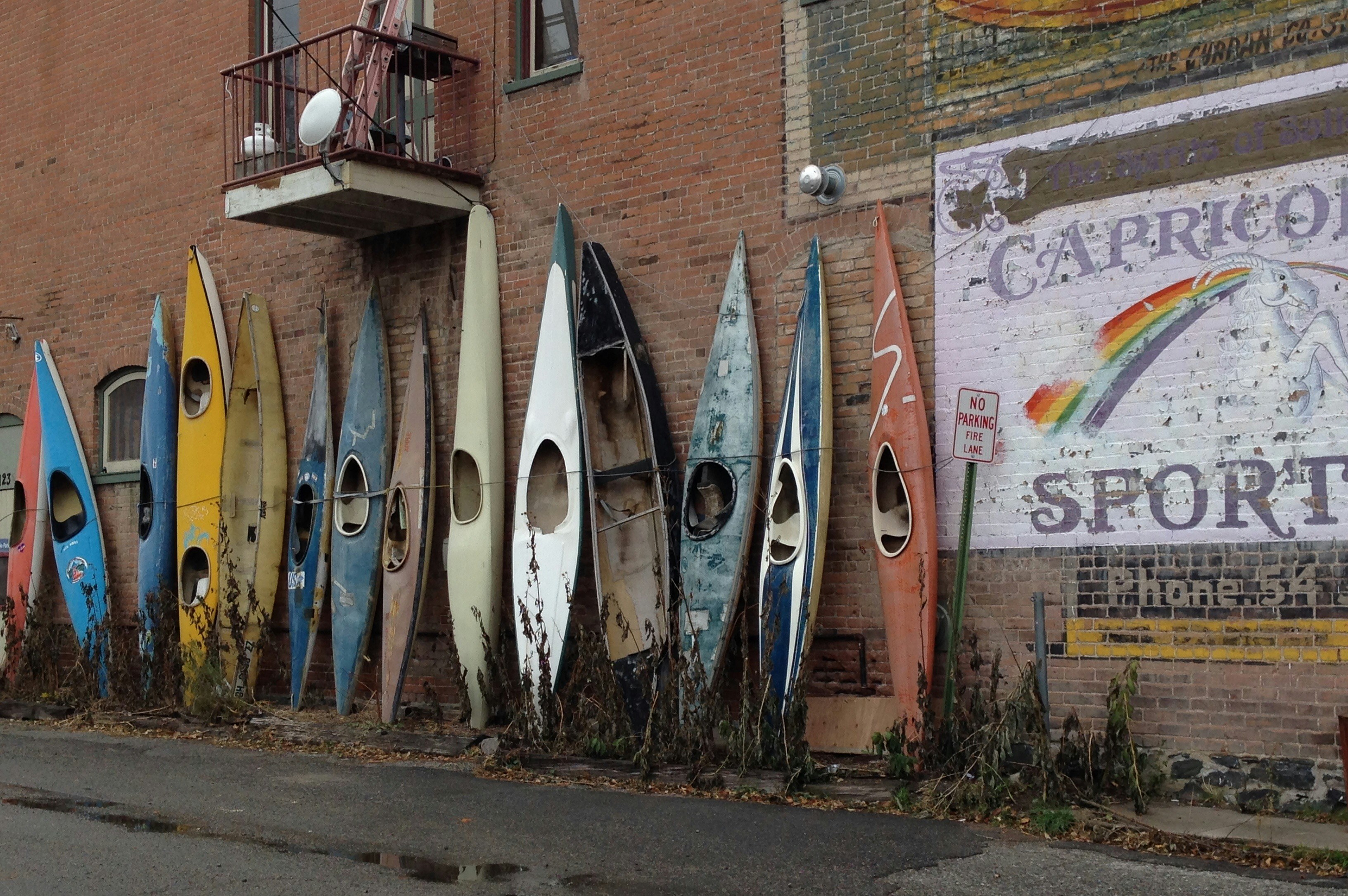 White and blue surfboard leaning on brown brick wall